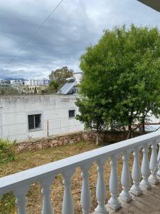 a white balcony with a tree and a building at VILLA MARLEN in Ksamil +6 photos