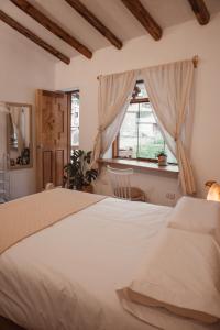 een slaapkamer met een wit bed en een raam bij Casa Faustina - Pisac in Cuzco