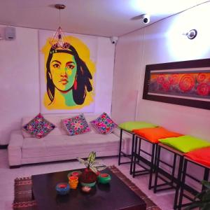 ein Wohnzimmer mit einem Sofa und 2 Hockern in der Unterkunft Kuyay Hostel in Bogotá