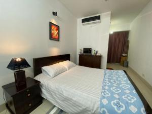 a bedroom with a large bed and a nightstand with a bed sidx sidx sidx at Cozy Ac Private bedroom Gulshan 1 - 6km Airport in Dhaka