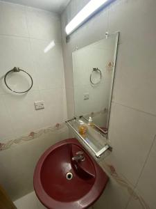 a bathroom with a red sink and a mirror at Cozy Ac Private bedroom Gulshan 1 - 6km Airport in Dhaka