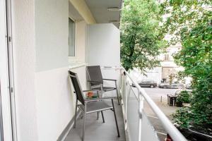- Balcón con 2 sillas y mesa en Wiesbaden - Apartment im Nerotal, en Wiesbaden