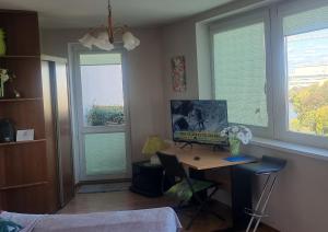 sypialnia z biurkiem i 2 oknami z zielonymi żaluzjami w obiekcie Słoneczny apartamencik we Wrocławiu