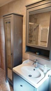 ein Bad mit einem Waschbecken und einem Spiegel in der Unterkunft Lipicai Hotel és Étterem in Szilvásvárad