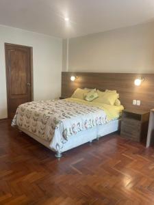 a bedroom with a large bed with a wooden headboard at FLAT AMOBLADO EN PUEBLO LIBRE - LIMA - PERÚ in Lima
