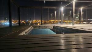 a swimming pool on the roof of a building at night at Departamento nuevo 1D1B estacionamiento privado gratis in Viña del Mar