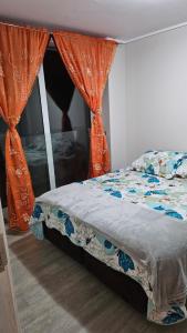 1 dormitorio con 1 cama con cortina naranja en Departamento nuevo 1D1B estacionamiento privado gratis en Viña del Mar