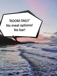 una foto del océano con un cartel que lee solo la habitación sin opciones de comida no en Westcliff, en Seascale
