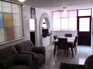 a living room with a couch and a table and chairs at Departamento, 2 Recamaras, Familiar o Equipos de Trabajo, WiFi incluido in Tepotzotlán