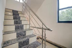 eine Treppe in einem Haus mit Fenster in der Unterkunft Super OYO Hotel Elite Inn in Korādih