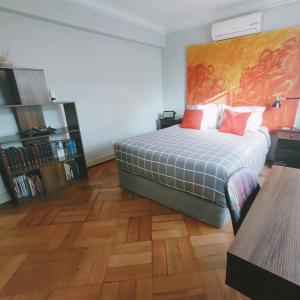 Schlafzimmer mit einem Bett und Holzboden in der Unterkunft Mahatma Hostel in Santiago