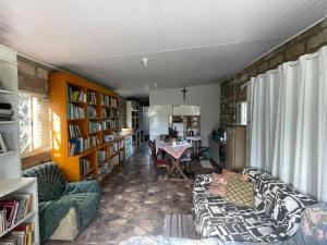 a living room with two couches and a table and books at Instituto Bugio Ruivo in Eldorado do Sul 