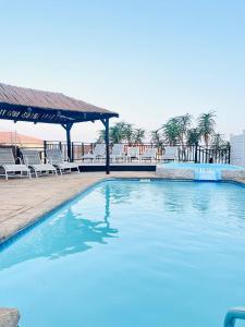 a large swimming pool with chairs and a gazebo at Illovo Beach View Apartment at Illovo Views in Kingsburgh