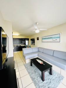 a living room with a couch and a table at Illovo Beach View Apartment at Illovo Views in Kingsburgh