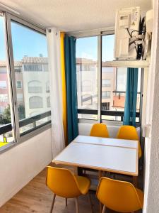 a table and chairs in a room with a window at Studio Chaleureux au Cap d’Agde in Cap d'Agde