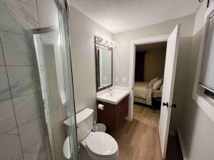 a bathroom with a toilet and a sink and a mirror at One Bedroom Condo Near Whyte Ave Close to university in Edmonton