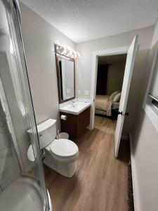 y baño con aseo, lavabo y espejo. en One Bedroom Condo Near Whyte Ave Close to university, en Edmonton