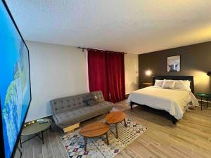 a hotel room with a bed and a flat screen tv at One Bedroom Condo Near Whyte Ave Close to university in Edmonton