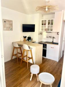 une cuisine avec une table, deux chaises et un comptoir dans l'établissement Studio Chaleureux au Cap d’Agde, au Cap d'Agde