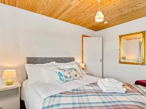 a bedroom with a bed with a wooden ceiling at Flaherty Cottage in Ballyconneely
