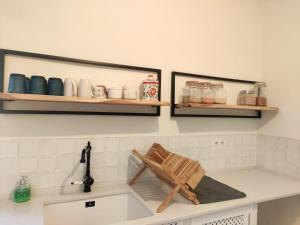 a kitchen with a sink with a wooden chair on the counter at Bonita casa blanca en el bosque. in Córdoba
