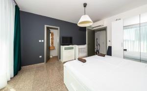 a bedroom with a white bed and a tv at Vertigo Huge Apartment 2 Bedrooms Balcony Parking in Sofia