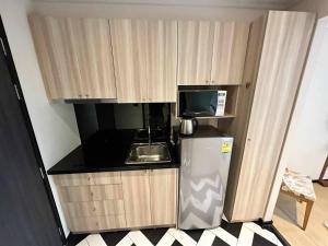 eine kleine Küche mit Mikrowelle und Kühlschrank in der Unterkunft Venetian Signature Condo Resort Pattaya in Jomtien Beach