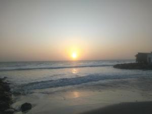um pôr-do-sol numa praia com o oceano em Casa de Playa en Colan Casa Merino. em Paita