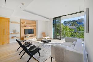 a living room with a couch and chairs and a tv at Marina 107 in Cape Town
