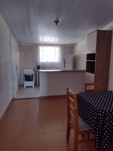 a room with a kitchen with a table and a stove at Pousada das Estrelas in São Pedro