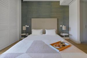 a large white bed with a tray of donuts on it at Marina 107 in Cape Town +30 photos