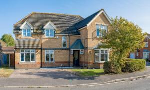 a brick house with a tree in front of it at The Opulent House Kent in Sheerness