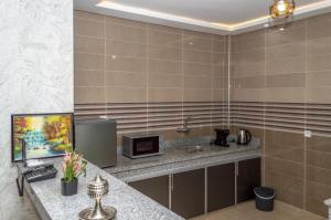 La salle de bains est pourvue d'un lavabo et d'un comptoir avec un four micro-ondes. dans l'établissement Palm D'or-Appartement familial de luxe au centre de Dakhla, à Dakhla