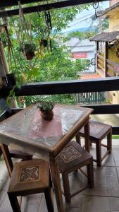 uma mesa de madeira com um vaso de plantas numa varanda em Pousada Mirante Pôr do Sol em Maricá