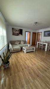ein Wohnzimmer mit einem Sofa und einem Tisch in der Unterkunft Piso Centro de Cullera in Cullera