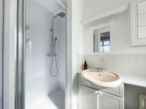 a white bathroom with a sink and a shower at The Opulent House Kent in Sheerness