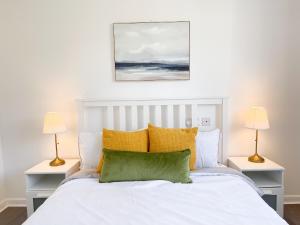 1 dormitorio con 1 cama blanca y 2 lámparas en The Opulent House Kent en Sheerness