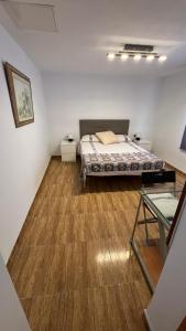 1 dormitorio con 1 cama y suelo de madera en Piso Centro de Cullera en Cullera