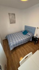 a small bedroom with a bed with a blue comforter at Piso Centro de Cullera in Cullera