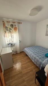 1 dormitorio con 1 cama y suelo de madera en Piso Centro de Cullera en Cullera