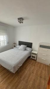 een witte slaapkamer met een bed en een dressoir bij Piso Centro de Cullera in Cullera