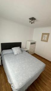 a bedroom with a bed and a dresser at Piso Centro de Cullera in Cullera