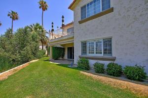 a white house with a green yard and palm trees at DL831 - Desert Falls Circle in Palm Desert