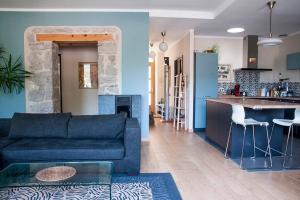 ein Wohnzimmer mit einem blauen Sofa und einer Küche in der Unterkunft Le balcon du boulevard bellevue in Saint-Claude
