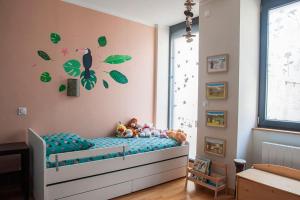 ein Kinderschlafzimmer mit einem Bett mit grünen Blättern darauf in der Unterkunft Le balcon du boulevard bellevue in Saint-Claude