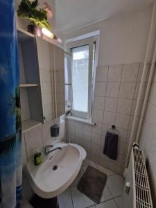 baño blanco con lavabo y ventana en Schöne 3 Schlafzimmer Zimmer Wohnung mit 4 Betten., en Berlín