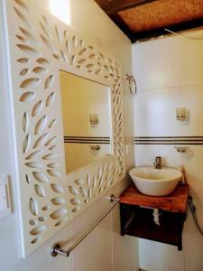 ein Bad mit einem Waschbecken und einem Wandspiegel in der Unterkunft WICHI LAGO in San Pablo