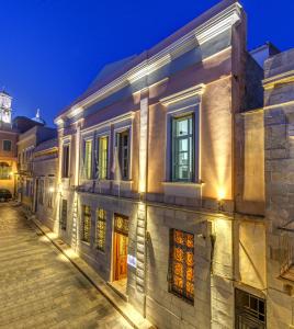 a building on a street at night at Apollonion Palace in Ermoupoli