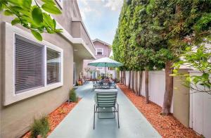 een patio met tafels en stoelen en een parasol bij Shared Luxury Beach house in Redondo Beach. Private 2 Bedrooms / Bath in Redondo Beach