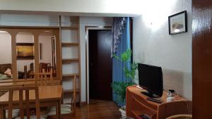 Zimmer mit einem Schreibtisch, einem TV und einer Tür in der Unterkunft Can Marti in Alfara de Carles